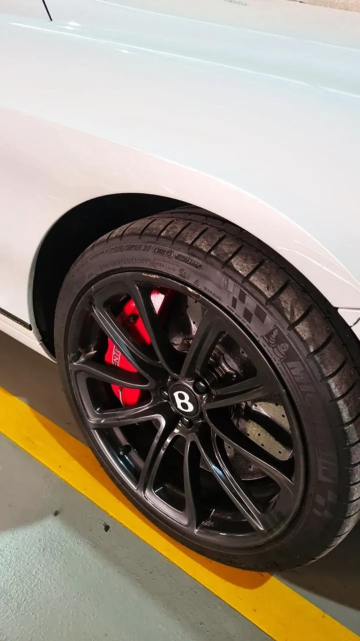 Bentley branco com roda em preto e pinça de freio vermelha