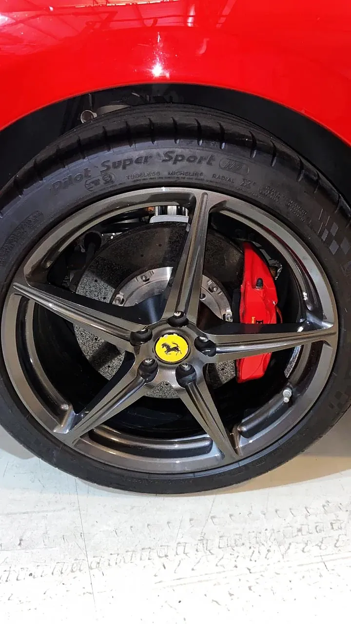 Ferrari vermelha com roda em grafite e pinça de freio vermelha