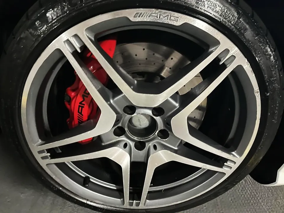 Roda AMG diamantada, face usinada e fundo escuro, com pinça de freio vermelha