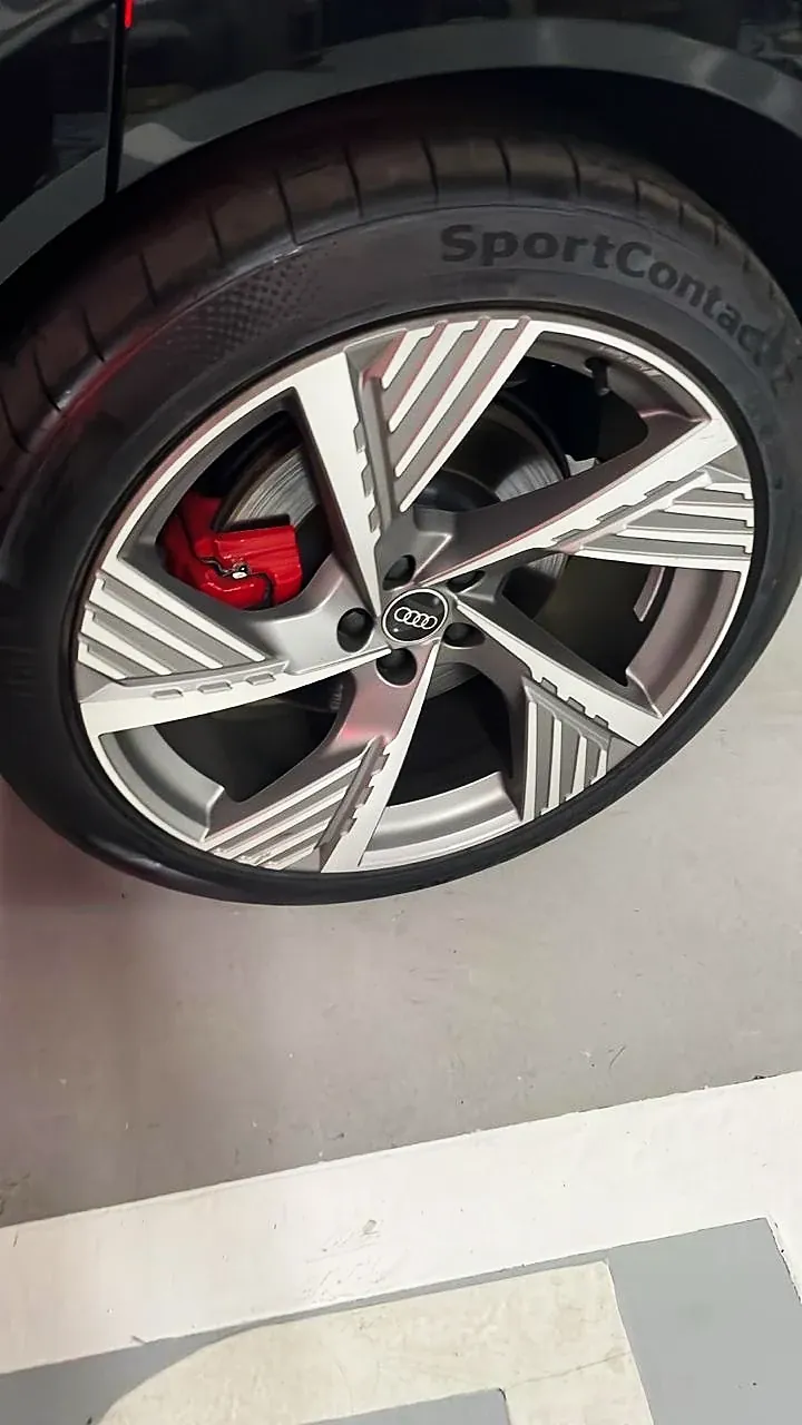 Roda Audi com face usinada e pinça de freio vermelha, pneu