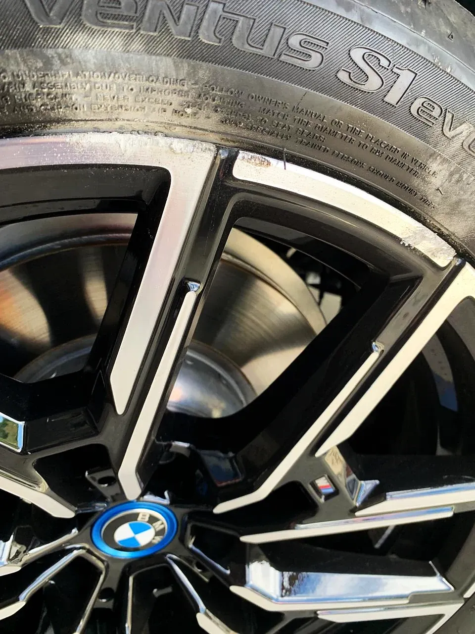 Roda BMW com face usinada em detalhe, com raios pretos e faces usinadas